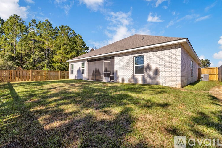 A house with a fence and trees in the background is for sale.