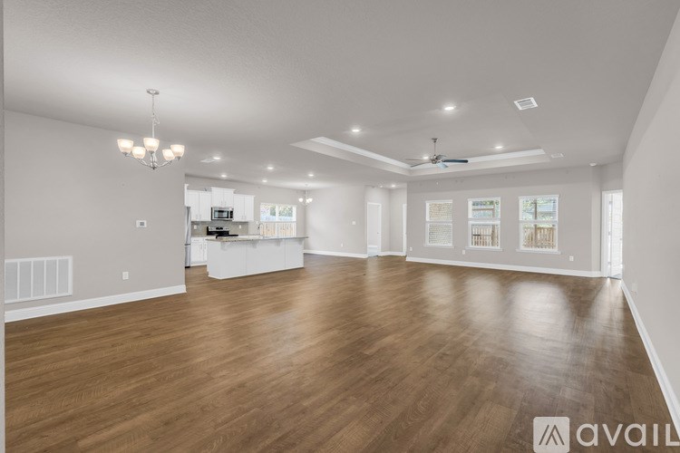 A spacious room with wooden floors and a ceiling fan.