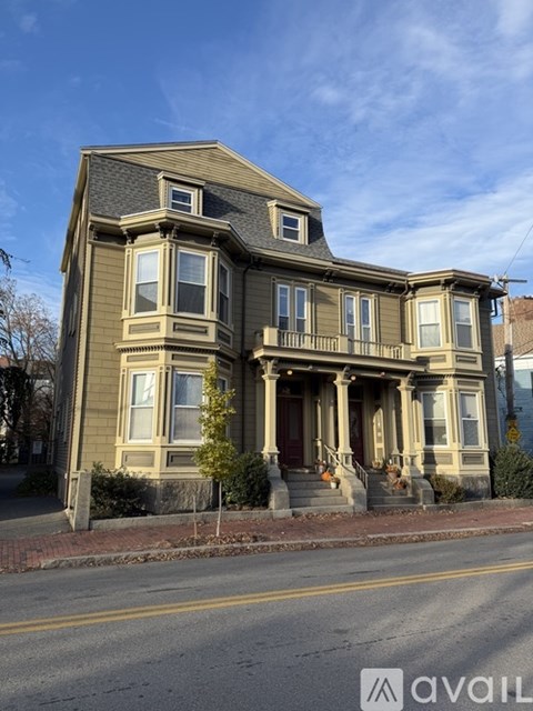 A large, two-story house with a front porch and multiple windows.