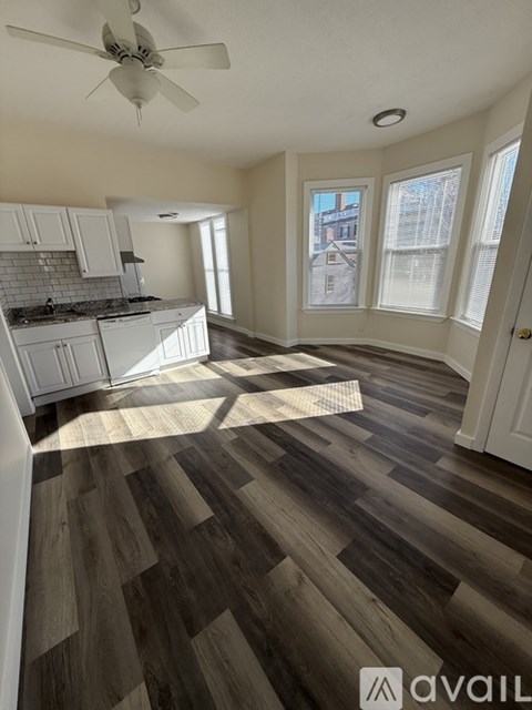 A room with wooden flooring and a ceiling fan.