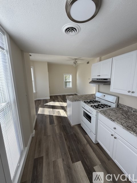 A kitchen with white cabinets and a granite countertop.
