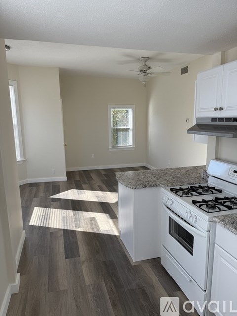 A kitchen with white appliances and a window.