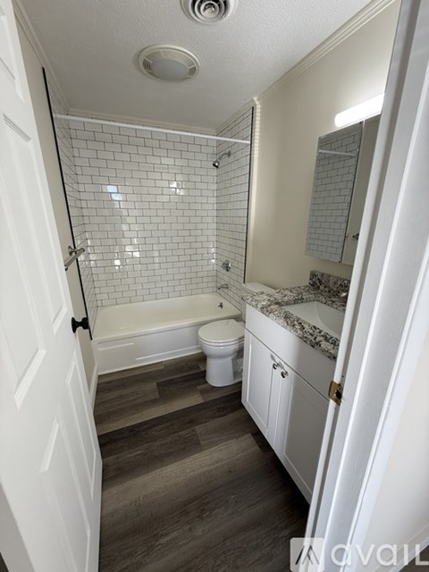 A white bathroom with a toilet, sink, and bathtub.