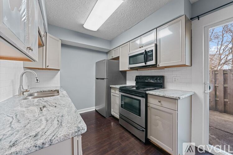 A kitchen with a granite countertop and stainless steel appliances.