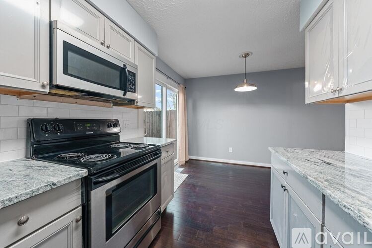 A kitchen with a stove top oven and microwave above it.