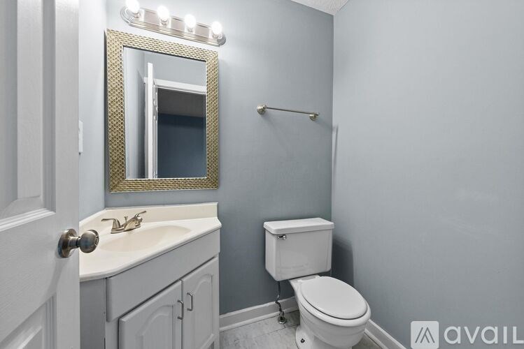 A bathroom with a toilet, sink, and mirror.