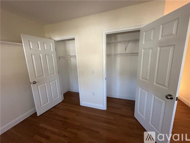 A room with two white doors and a wooden floor.