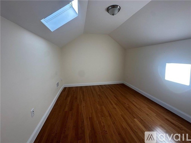 A room with wooden floors and a skylight.