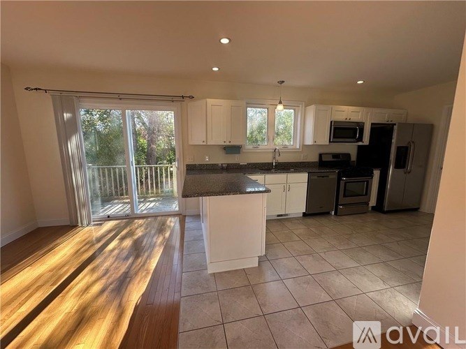 A kitchen with white cabinets and a black countertop.