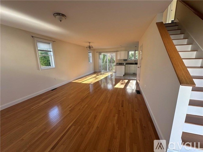 A long hallway with wooden floors and a staircase on the right side.
