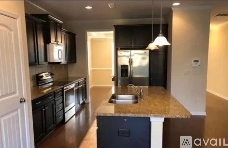 A kitchen with black cabinets and a granite countertop.