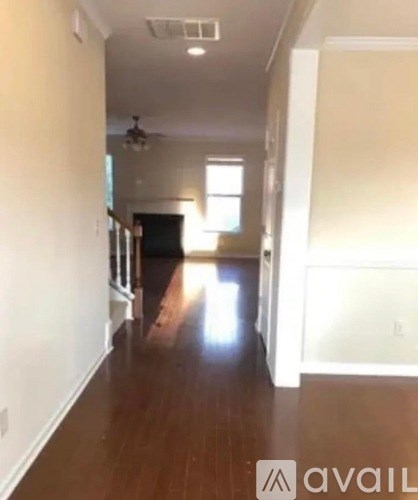 A long hallway with a fan and light on the ceiling.