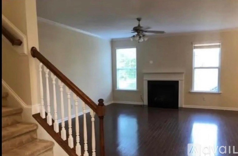 A living room with a fireplace and a staircase.