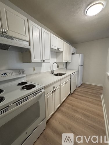 A kitchen with white cabinets and appliances.