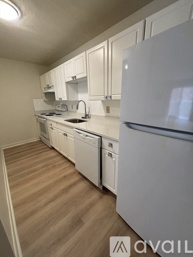 A kitchen with white appliances and cabinets.