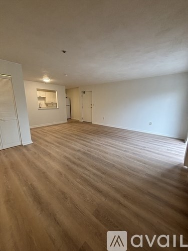 A room with wooden flooring and white walls, with a logo that reads "avaiL" in the bottom right corner.