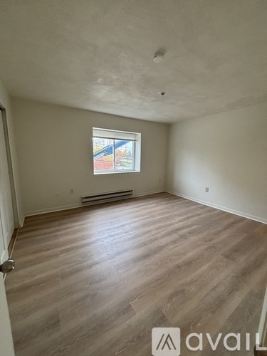 A room with wooden flooring and a window.