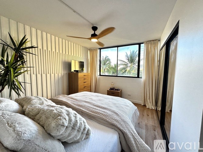 A bedroom with a large bed and a ceiling fan.