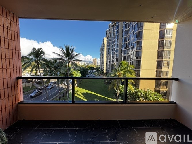 A balcony with a view of a road and palm trees.