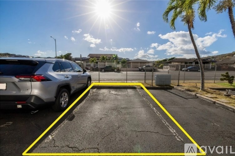 A car is parked in a parking lot with yellow lines.