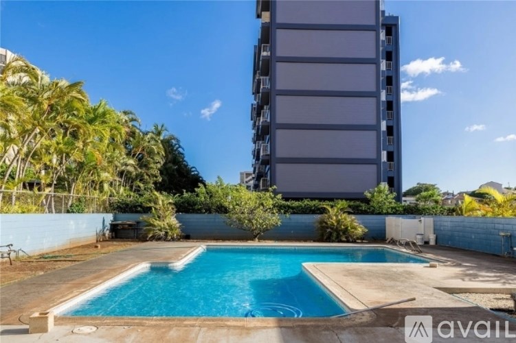 A swimming pool in a backyard with a tall building in the background.