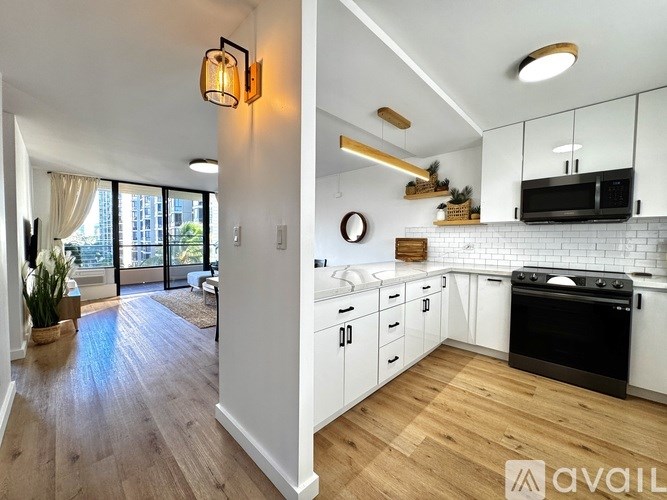 A modern kitchen with white cabinets and a black oven.