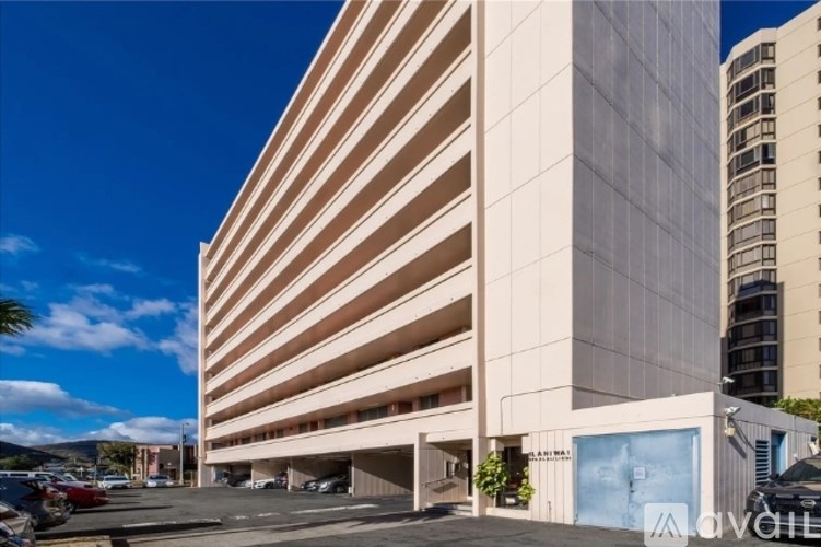 A large, modern building with a parking garage in front.