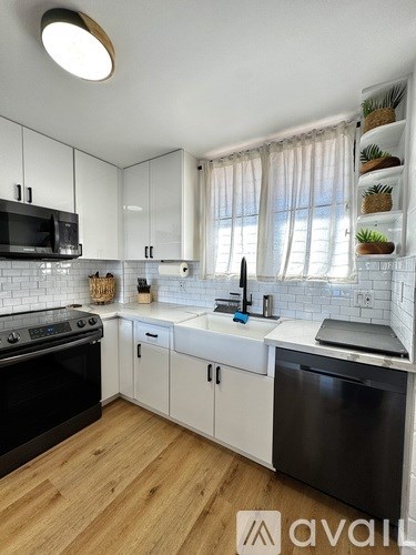 A kitchen with white cabinets and a black oven.