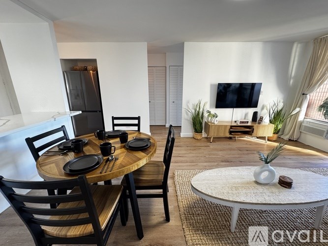 A modern dining room with a round wooden table and chairs.
