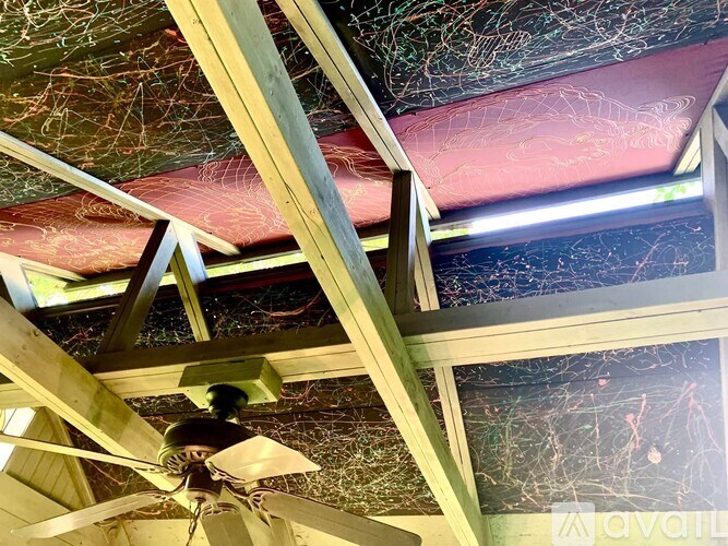 A ceiling fan is hanging from a wooden beam.