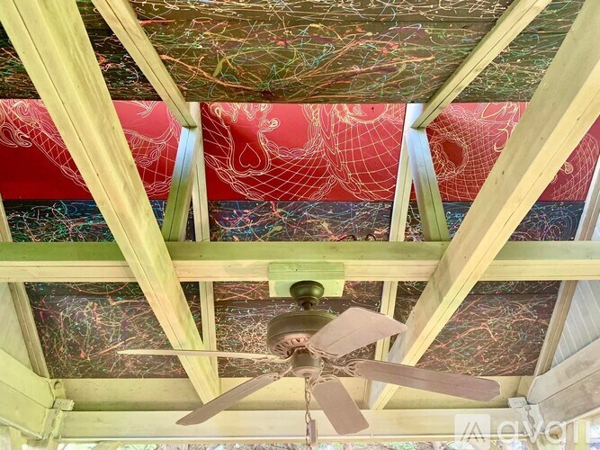 A ceiling fan hangs from a wooden beam.