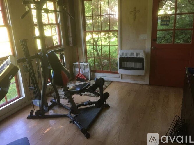A room with a treadmill, exercise bike, and a heater.