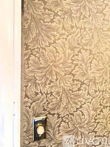 A door with a gold leaf pattern and a silver handle.