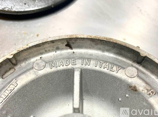 A close-up of a metal object with the text "MADE IN ITALY" visible.