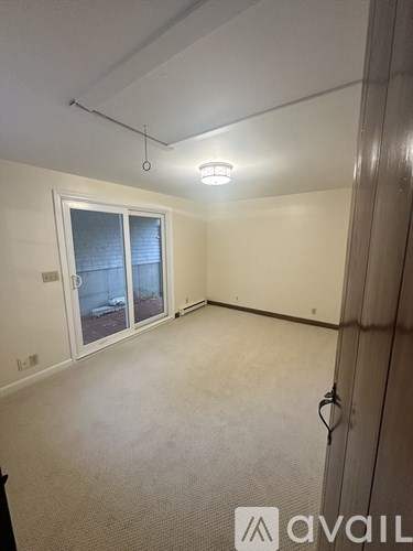 A room with a carpeted floor and a sliding glass door.