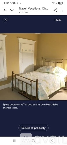 A bedroom with a bed, a change table, and a full bath.