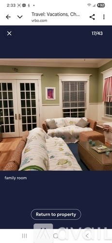 A family room with a couch, a bed, and a window.