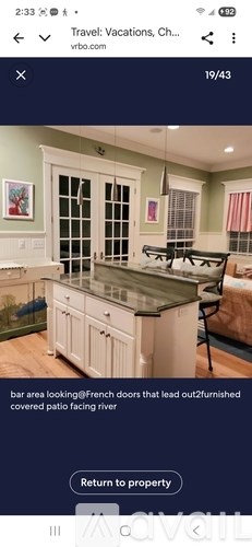 A kitchen with a bar area and French doors leading out.