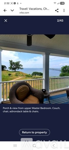 A porch with a view of the ocean and a couch.