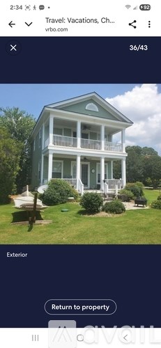 A blue house with white trim and a balcony.