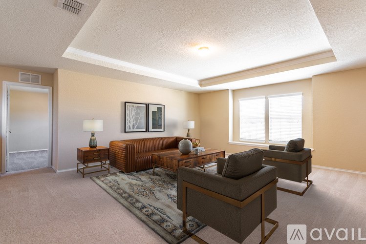 A living room with a brown couch, a rug, and a lamp.