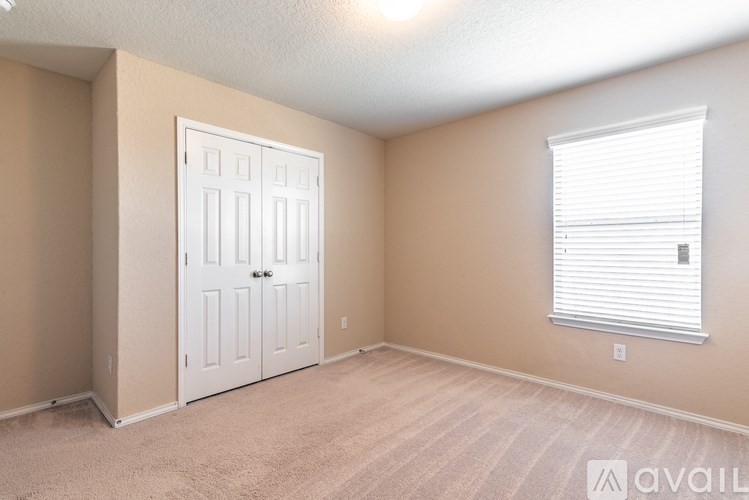 A room with a white door and a window with blinds.