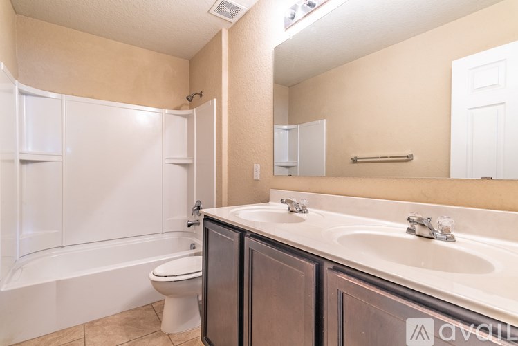 A bathroom with a white tub, sink, and toilet.