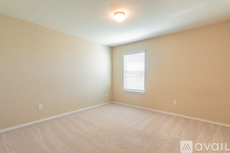 A room with a window and carpeted floor.