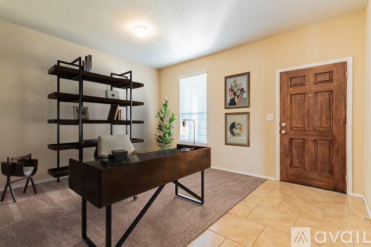 A room with a brown desk and a wooden door.
