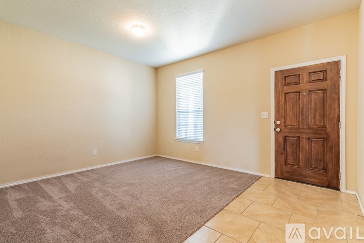 A room with a brown door and a window with blinds.