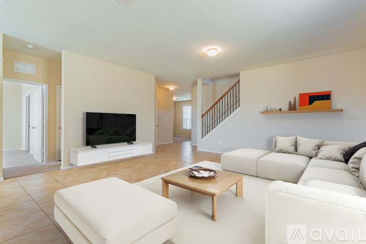 A living room with a white couch and a wooden coffee table.