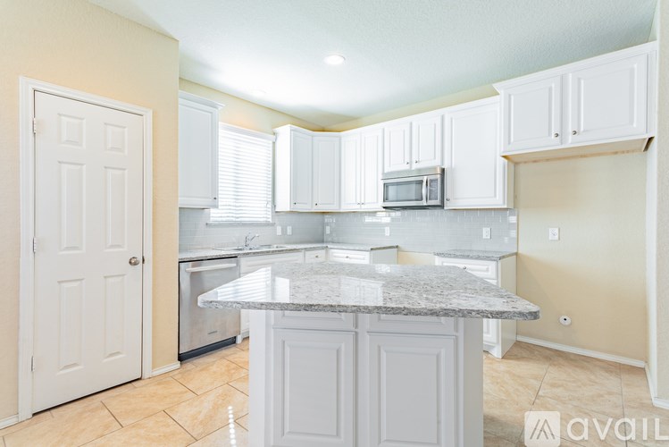 A kitchen with a granite countertop and white cabinets.