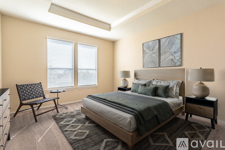 A bedroom with a bed, nightstand, chair, and window.