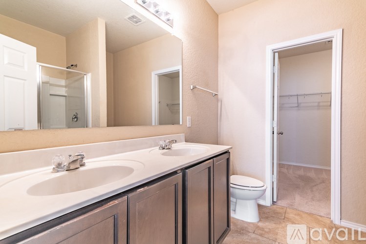 A bathroom with a sink, mirror, toilet and shower.